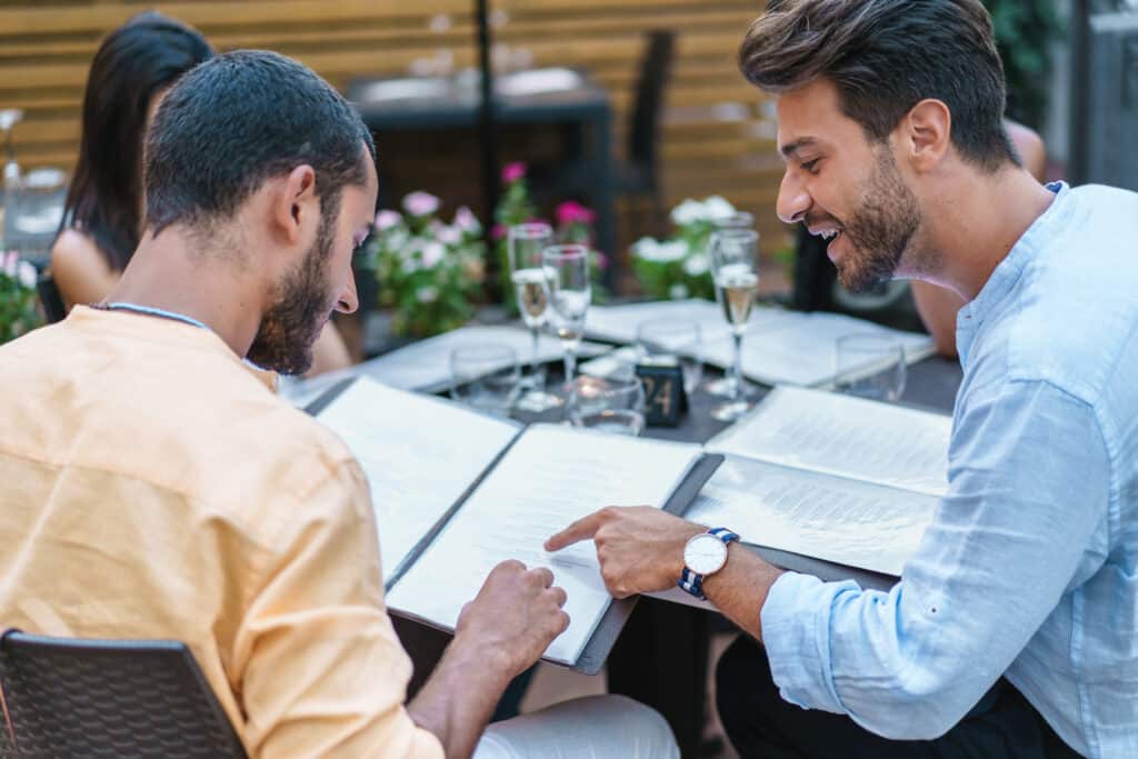 Zwei Männer zeigen auf ein Menü