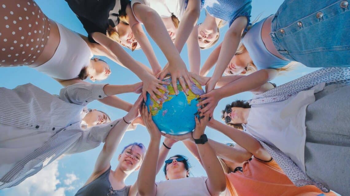 Internationale Privatschule Berlin – Jugendliche halten gemeinsam einen Globus und symbolisieren weltweite Bildung und kulturelle Vielfalt
