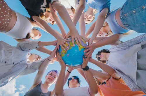 Internationale Privatschule Berlin – Jugendliche halten gemeinsam einen Globus und symbolisieren weltweite Bildung und kulturelle Vielfalt