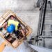 Bauarbeiter mit Schutzhelm arbeitet aus einem Arbeitskorb einer LKW-Arbeitsbühne
