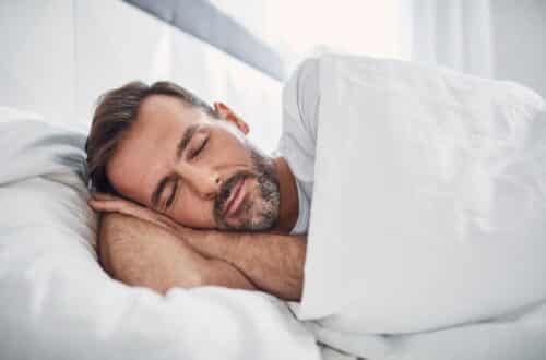 Mann schläft entspannt im Bett | Matratzenschutz